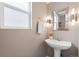 Simple bathroom with pedestal sink and updated vanity lighting at 5083 Perth Ct, Denver, CO 80249