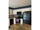 White kitchen with black appliances and granite countertops at 542 E Caley Dr, Centennial, CO 80121