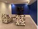 Finished basement recreation room with two armchairs and large TV at 542 E Caley Dr, Centennial, CO 80121
