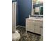Bathroom with pebble stone floor and white vanity at 542 E Caley Dr, Centennial, CO 80121