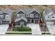 Two-story home with gray siding, stone accents, and a landscaped yard at 890 Meadowlark Dr, Erie, CO 80516