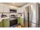 Modern kitchen with stainless steel appliances and green cabinets at 3110 S Halifax St, Aurora, CO 80013