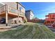 Large backyard with grassy area, deck, playset, and patio at 9299 Rifle St, Commerce City, CO 80022