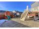 Backyard with patio, playset, and stairs leading to a deck at 9299 Rifle St, Commerce City, CO 80022