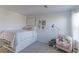 Bedroom with a queen bed, pink armchair, and built-in shelves at 9299 Rifle St, Commerce City, CO 80022