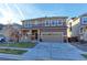 Two-story home with attached garage and landscaped front yard at 9299 Rifle St, Commerce City, CO 80022