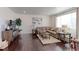 Living room features hardwood floors, a sectional sofa, and a large TV at 9299 Rifle St, Commerce City, CO 80022