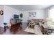 Living room with hardwood floors, sectional sofa, and large artwork at 9299 Rifle St, Commerce City, CO 80022