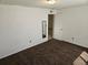 Bright bedroom with brown carpet and door to another room at 1446 Jamaica St, Aurora, CO 80010