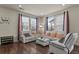 Living room with white reclining sofas, coffee table, and hardwood floors at 6251 N Malaya St, Aurora, CO 80019