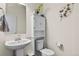 Small bathroom with pedestal sink, toilet, and storage cabinet at 6251 N Malaya St, Aurora, CO 80019