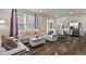 Bright living room with white couches, coffee table, and hardwood floors at 6251 N Malaya St, Aurora, CO 80019