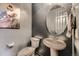 Small bathroom with pedestal sink, toilet, and an oval mirror at 3438 Cade Ct, Castle Rock, CO 80104