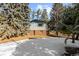 Brick and wood home with a snow covered yard and trees at 5274 S Hatch Dr, Evergreen, CO 80439