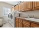 Convenient laundry room with washer, dryer, and wood cabinets at 10834 Bobcat Ter, Lone Tree, CO 80124