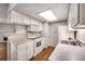 White kitchen features cooktop, microwave, and cabinets at 8335 Fairmount Dr # 9-206, Denver, CO 80247