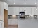 Modern kitchen with white cabinets, stainless steel appliances and an island at 13502 E 100Th Ave, Commerce City, CO 80022
