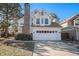 Two-story home with white siding, attached garage, and brick chimney at 1147 S Flower Cir, Lakewood, CO 80232