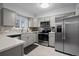 Sleek kitchen featuring stainless steel appliances, gray cabinetry, and white countertops at 5747 S Lowell Blvd, Littleton, CO 80123