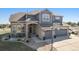 Two-story house with stone and gray siding, three-car garage, and basketball hoop at 9508 E 147Th Ave, Brighton, CO 80602