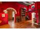 Red-walled entryway with arched doorways and hardwood floors at 5280 S University Blvd, Greenwood Village, CO 80121