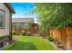 Landscaped backyard with a wooden fence and grassy area at 15373 E 113Th Pl, Commerce City, CO 80022