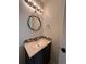 Updated bathroom with a vanity and a round mirror at 2604 S Dunkirk Ct, Aurora, CO 80013