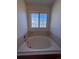 Bathroom with a large garden tub and window at 2604 S Dunkirk Ct, Aurora, CO 80013