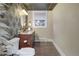 Elegant powder room with a patterned wallpaper and granite vanity at 1490 Saint Andrews Dr, Broomfield, CO 80020