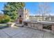Outdoor kitchen with brick oven, grill, and stamped concrete patio at 1490 Saint Andrews Dr, Broomfield, CO 80020