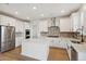 Spacious kitchen featuring white cabinets, herringbone backsplash, and large island at 42980 Colonial Trl, Elizabeth, CO 80107