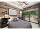 Bedroom with wood-paneled wall and sliding glass doors to patio at 11164 Beatrice Ct, Littleton, CO 80125