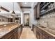 Basement bar with granite countertop, wine storage, and built-in microwave at 11164 Beatrice Ct, Littleton, CO 80125