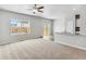 Spacious living room with neutral carpet, large windows, and sliding glass doors at 2164 Alyssa St, Fort Lupton, CO 80621