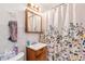 Clean bathroom with floral shower curtain and a vanity at 4545 Raritan St, Denver, CO 80211