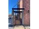 View of the building entrance with a secure gate and brick exterior at 529 N Washington St # 304, Denver, CO 80203