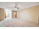 Spacious bedroom with neutral walls, carpet, and ceiling fan; access to bathroom and closets at 350 S Clinton St # 7A, Denver, CO 80247