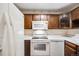 Kitchen with dark wood cabinets and white appliances at 350 S Clinton St # 7A, Denver, CO 80247