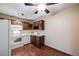 Kitchen with dark wood cabinets, white appliances, and wood-look floors at 350 S Clinton St # 7A, Denver, CO 80247