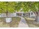 Tan siding condo building with walkway, landscaping, and a tree with fall leaves at 2604 S Xanadu Way # B, Aurora, CO 80014