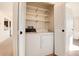 In-unit laundry with washer and dryer, plus shelving for storage at 13961 E Marina Dr # 106, Aurora, CO 80014