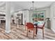 Dining area with a glass table, modern chandelier, and access to the backyard at 1490 S Ivy Way, Denver, CO 80224