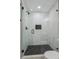 Large walk-in shower with marble-look tile and a hexagonal floor at 4643 S Cherokee St, Englewood, CO 80110