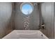 Modern bathroom with a large round window and a bathtub at 1820 S State Highway 83, Franktown, CO 80116