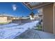 View from the back patio showing a snow-covered yard and neighboring buildings at 266 S Oman Rd, Castle Rock, CO 80104