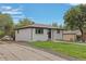 White ranch home with driveway, landscaping, and detached garage at 7946 Joan Dr, Denver, CO 80221
