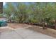 Large backyard with mature trees and a concrete patio at 7946 Joan Dr, Denver, CO 80221
