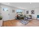 Living room with green sofa, wood floors, and geometric rug at 7946 Joan Dr, Denver, CO 80221
