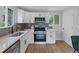 Modern kitchen featuring white cabinets, stainless steel appliances, and quartz countertops at 7946 Joan Dr, Denver, CO 80221