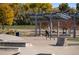 Concrete skate park with ramps, rails, and a shaded seating area at 13345 W 72Nd Cir, Arvada, CO 80005